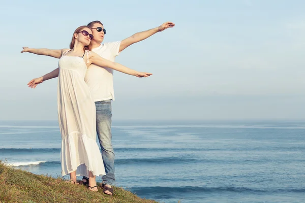 Älskande par stående på stranden på dagarna. — Stockfoto