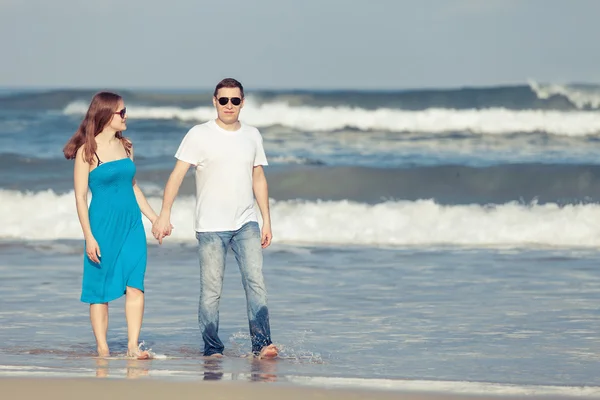 Älskande par stående på stranden på dagarna. — Stockfoto