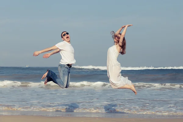 Casal amoroso correndo na praia na hora do dia . Imagem De Stock