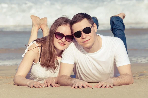 Loving couple lying on the beach at the day time. — Stock Photo, Image