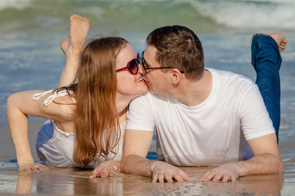 Coppia amorevole sdraiata sulla spiaggia durante il giorno . — Foto Stock
