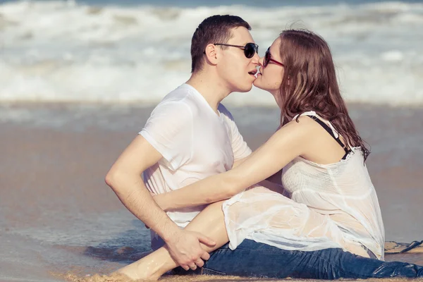 Miłości para siedzi na plaży w czasie dnia. — Zdjęcie stockowe