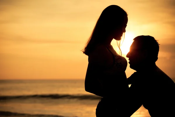 Paar in liefde terug lichte silhouet op zee bij de zonsondergang keer — Stockfoto