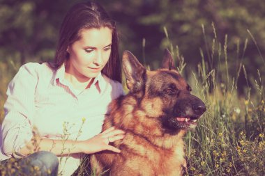 Genç güzel kız bahçede oynayan bir Alman çoban ile