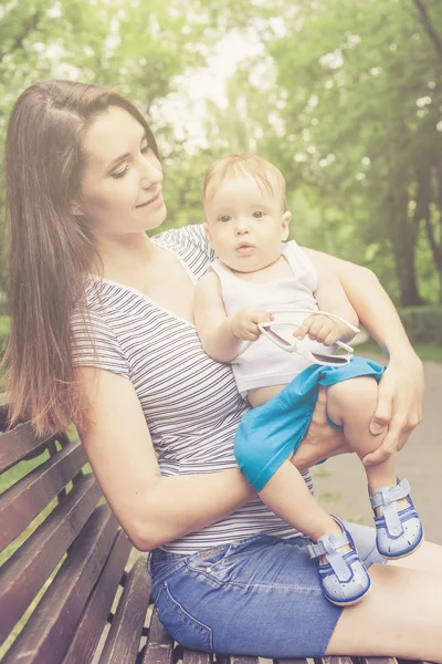 Glad mamma leker med hennes barn i parken — Stockfoto