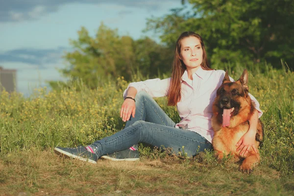 Genç güzel kız bahçede oynayan bir Alman çoban ile