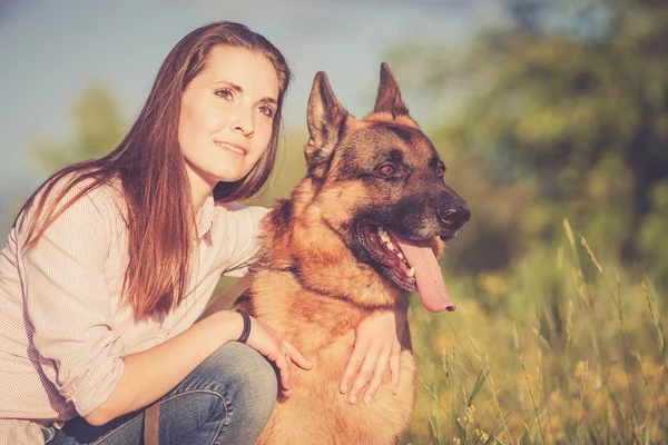 Young beautiful girl with a German shepherd playing on the lawn — Stock Photo, Image