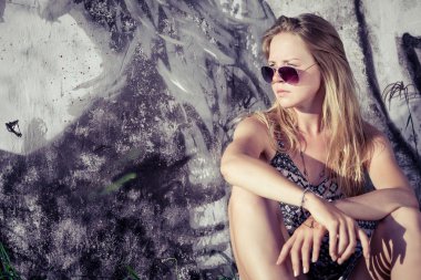portrait of a beautiful blonde girl near the wall