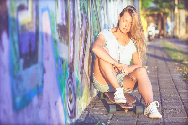 Модный образ жизни, молодая блондинка с скейтбордом — стоковое фото