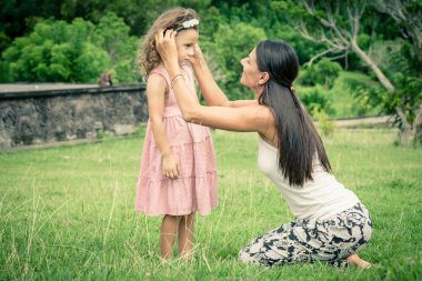 Anne ve kızı çimlere gün anda oynamak.