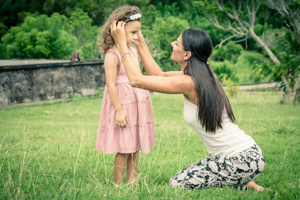 Mor och dotter började spela på gräset med dagen. — Stockfoto