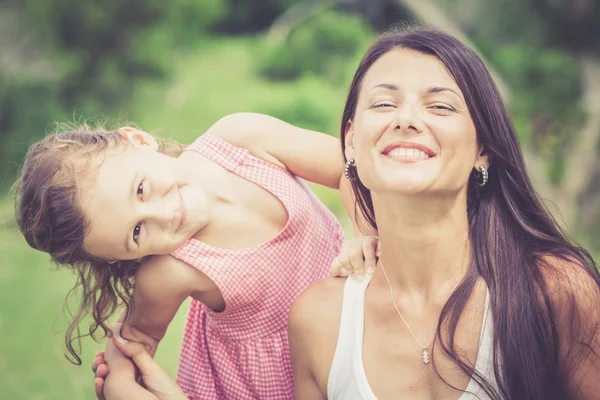 Glückliche Mutter und Tochter spielen tagsüber im Park. — Stockfoto