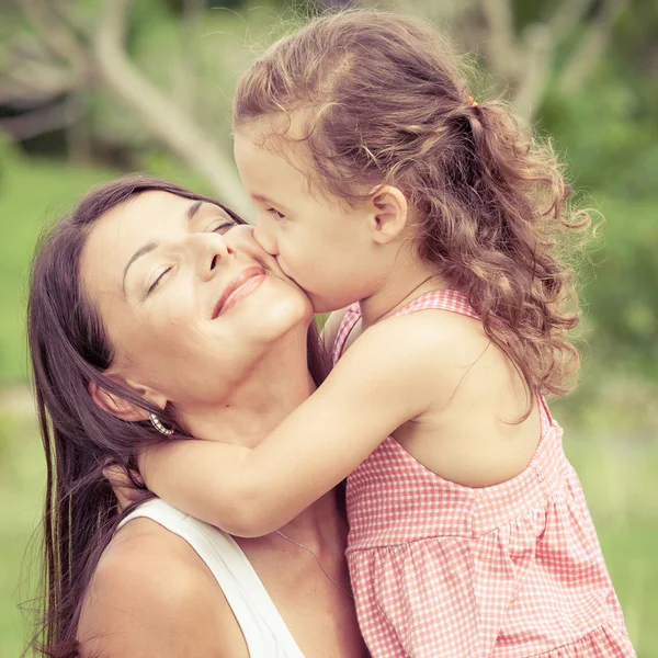 Glückliche Mutter und Tochter spielen tagsüber im Park. — Stockfoto