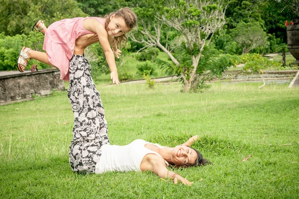 Glückliche Mutter und Tochter spielen tagsüber im Park. — Stockfoto