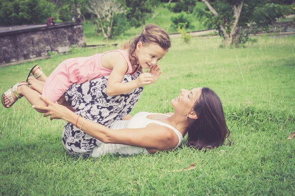 Glückliche Mutter und Tochter spielen tagsüber im Park. — Stockfoto