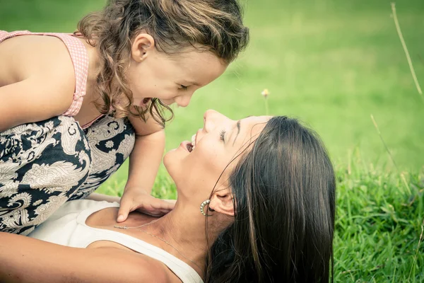 Madre e hija jugando en la hierba durante el día . — Foto de Stock