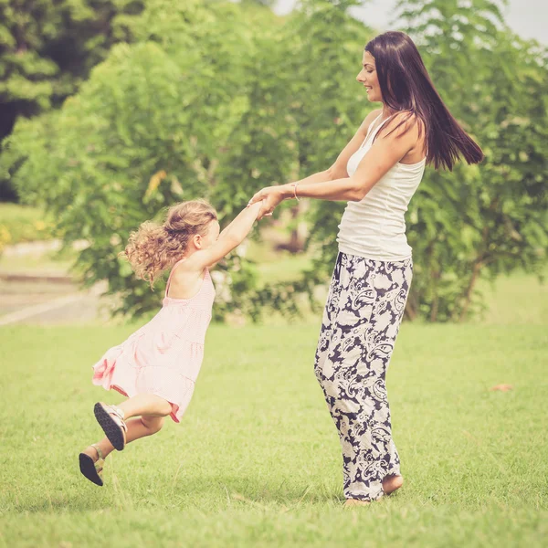 Lycklig mor och dotter började spela i parken med dagen. — Stockfoto