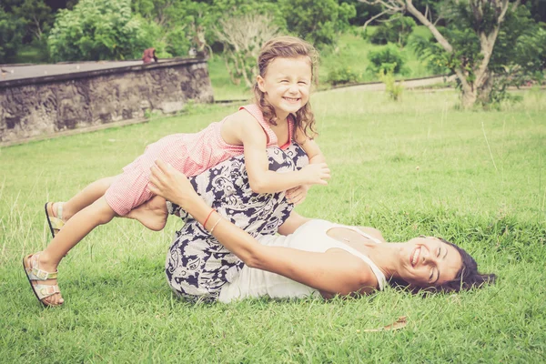 Mãe e filha felizes brincando no parque durante o dia . Fotografias De Stock Royalty-Free