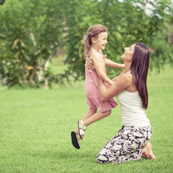 Mãe e filha felizes brincando no parque durante o dia . Imagens Royalty-Free