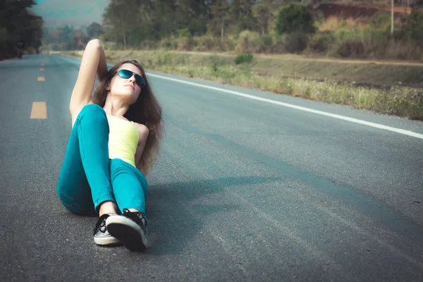 Trendi csípő lány a napszemüveg az úton a th pihentető — Stock Fotó