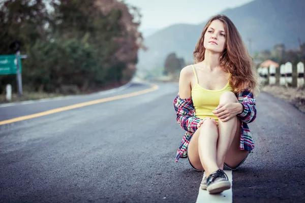 Menina Hipster na moda Relaxando na estrada na hora do dia . Fotos De Bancos De Imagens