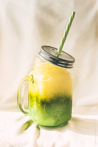 Kavanozlarda yeşil smoothie ve beyaz arka planda elma. Sağlıklı bir içki. Detox.