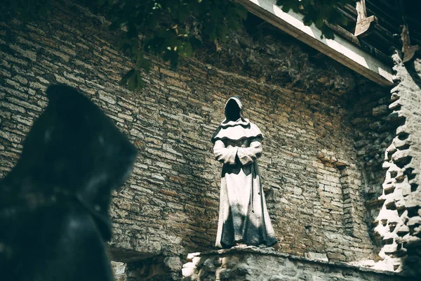 Tallinn, Estonya - 3 Ağustos 2019: Eski şehirdeki siyah keşişler tuğla duvara karşı heykeller yapıyorlar