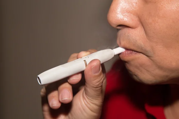 Куріння гібридного бездимного сигаретного пристрою, який використовує справжній тютюн — стокове фото