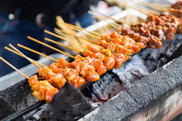 Satıcı üzerinde kömür ızgara tavuk ve sığır eti ızgara satay hazırlanıyor