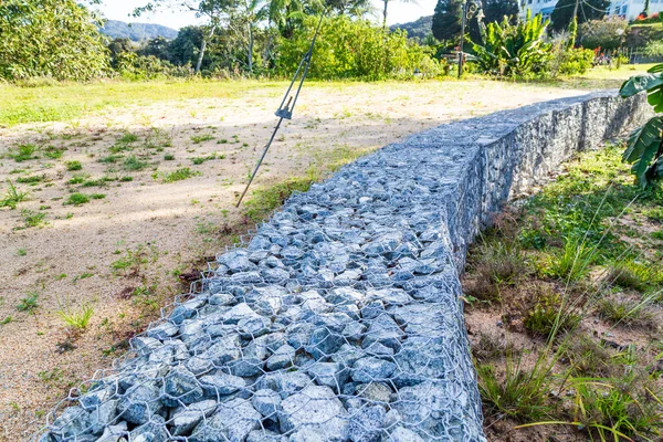 Muro de retención de tierra de pendiente con rocas y jaula de malla de alambre —  Fotos de Stock