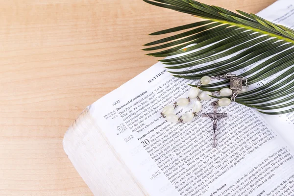 Closeup Catholic rosary with crucifix and beads on palm leaf — Stock Photo, Image