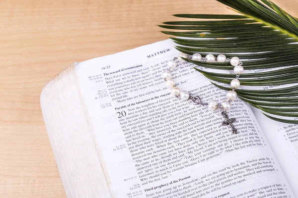 Nahaufnahme katholischer Rosenkranz mit Kruzifix und Perlen auf heiliger Bibel — Stockfoto