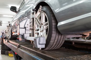 Otomatik tekerlek hizalama geçiren aligner ile sabitlenmiş lastik closeup