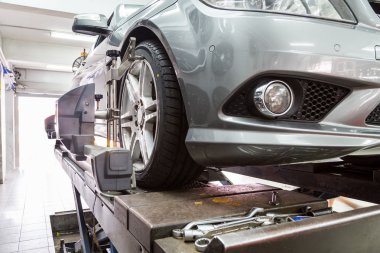 Otomatik tekerlek hizalama geçiren aligner ile sabitlenmiş lastik closeup