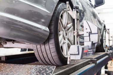Otomatik tekerlek hizalama geçiren aligner ile sabitlenmiş lastik closeup