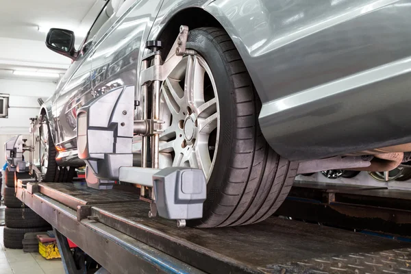 Primer plano del neumático sujetado con alineador que se somete a la alineación automática de la rueda — Foto de Stock