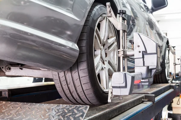 Close-up van band geklemd met aligner ondergaan auto wiel uitlijning — Stockfoto