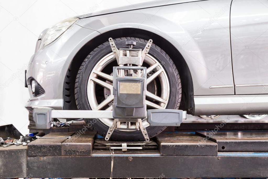 Closeup of tire clamped with aligner undergoing auto wheel alignment
