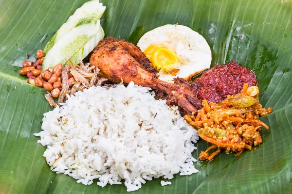 Close-up na culinária tradicional nasi lemak na folha de banana com frango frito — Fotografia de Stock