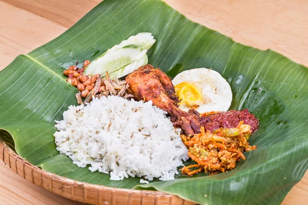 Masakan nasi lemak tradisional di daun pisang dengan ayam goreng — Stok Foto