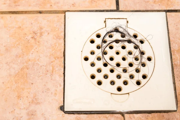 Bunch of hair trapped at bathroom shower drain outlet — Stockfoto