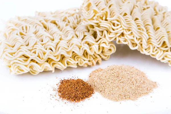 Unhealthy flavoring powder with uncooked instant noodles in white background — Stock Photo, Image