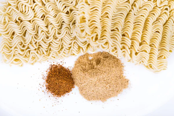 Closeup on unhealthy flavoring powder with uncooked instant noodle — Stock Photo, Image