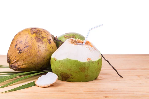 Drie verfrissende groene biologische kokosnoot vruchtensap op houten tafel — Stockfoto