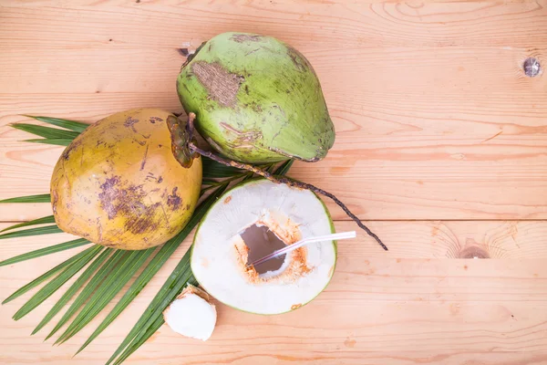 Tiga buah kelapa hijau segar organik jus buah pada tab kayu — Stok Foto