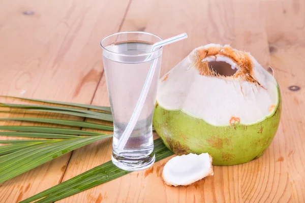 Menyegarkan jus buah kelapa hijau dalam gelas di atas meja kayu — Stok Foto