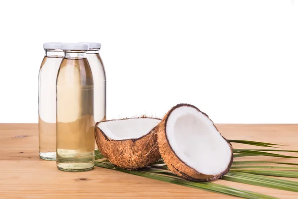 Óleo de coco extra virgem prensado a frio em garrafas com cocos — Fotografia de Stock