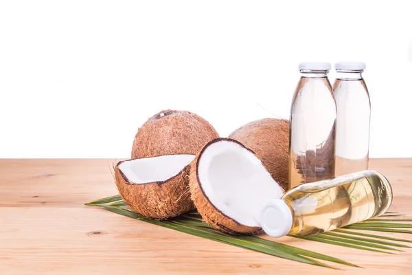 Óleo de coco extra virgem prensado a frio em garrafas com cocos — Fotografia de Stock