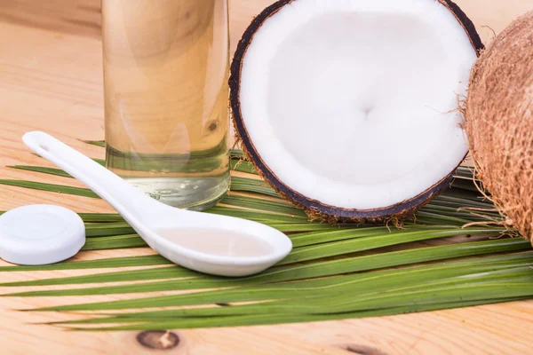 Cold pressed extra virgin coconut oil in bottles with coconuts