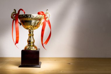 Ahşap masa kırmızı dekoratif şeritler ile Altın Kupa